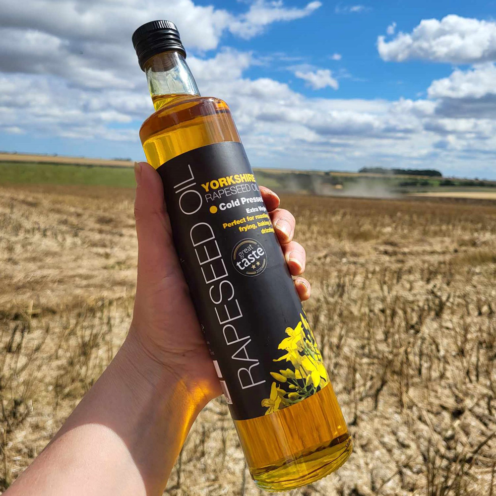 Bottle of rapeseed oil in the field