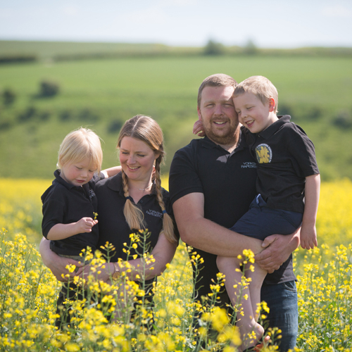 The Palmer Family standing in a rapeseed flower field
